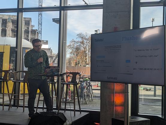 boris on stage with slide describing flushes app