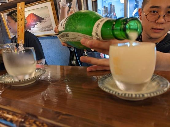 Person pouring sake into a cup 
Doburoku