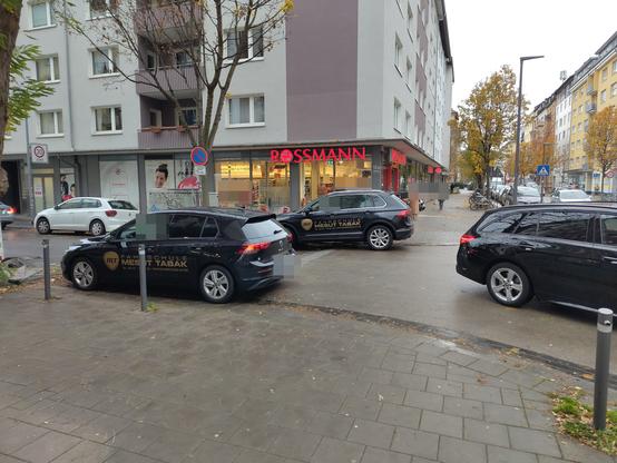Zwei Farschulautos stehen im Einmündungsbereich sowohl auf der linken als auch rechten Fahrbahnseite.