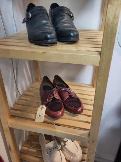 black red and white shoes on a wooden shelf