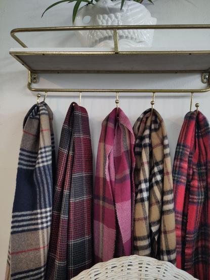 multicoloured scarves hanging on hooks on the wall