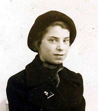 Portrait photograph of a young woman wearing a dark coat and hat.