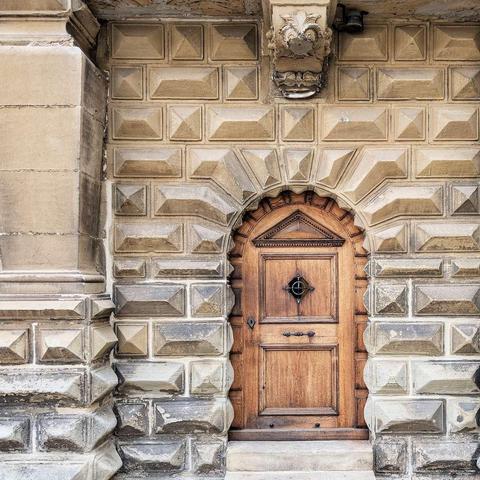 A close-up view of an ornate, wooden, historic castle door recessed into the rusticated sandstone wall of Kronborg Castle.