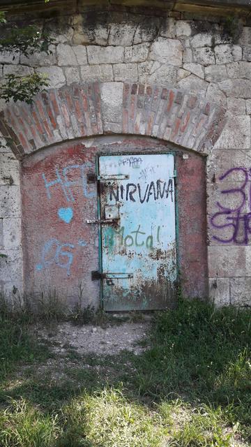 In einer Mauer aus Napoleonischen Zeiten ist eine Tür eingelassen, auf die geheime Akteure "NIRVANA" aufsprühten. Ob sie stat "Motal" eigentlich "Mortal" aufsprühen wollten?