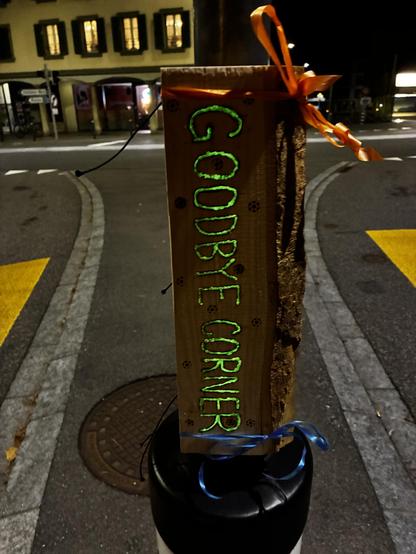 Goodbye corner wood is installed on a lamppost. The letters glow in the dark.