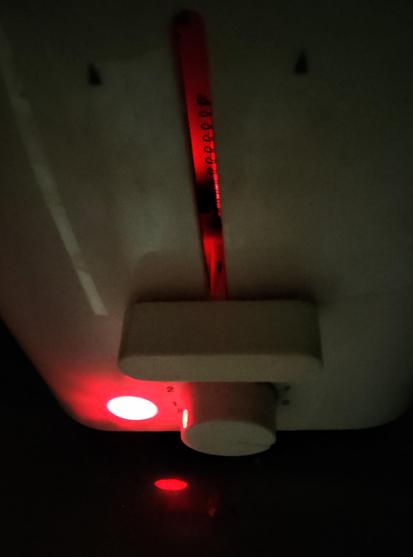 The toaster's power light glows, and is reflected in the glass tabletop. More glow from inside the toaster, as the toast within toasts round side down.