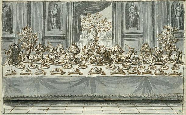 Détail d'un dessin à l'encre brune sur papier. Une table recouverte d'une nappe, très longue, est disposée dans une pièce dont on voit le pavement régulier en bas et les murs décorés de niches avec statues et de pilastres. Au centre, une fenêtre ouverte.
Sur la table de nombreux plats très décorés, avec notamment au centre une sorte de petite montagne couronnée d'un arbre et sur laquelle sont plusieurs personnages en train de jouer de la musique. Autour, d'autres plats qui représentent des bouquets, un cheval, des personnages mythologiques...