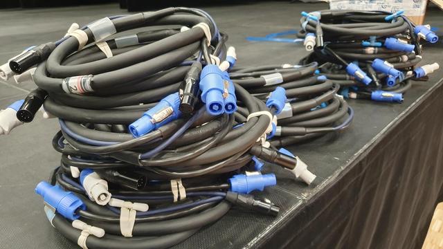 3 tas de câbles neufs bien enroulés sur une scène de spectacle.