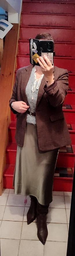 Grey mohair sweater vest over silly frilly blouse. Olive green satin skirt. Brown boots, belt, and brown wool check blazer.