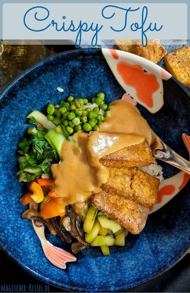 Dunkler Tisch. Darauf im Fokus eine große, dunkelblau glasierte Schale mit gelb-orangen Kois als Muster. In der Schale gebratenes Gemüse (Erbsen, Pak Choi, Paprika, Pilze, Gurke), goldbraun gebratener Tofu. Das Ganze auf einem Reisbett, gekrönt von brauner Erdnusssauce. Ein silberner Löffel liegt mit in der Schale. Im Hintergrund eine blassgraublaue Servierplatte mit Tofu-Nuggets.
Obendrüber ein graublaues Feld, auf dem in blauer Schrift "Crispy Tofu" steht.