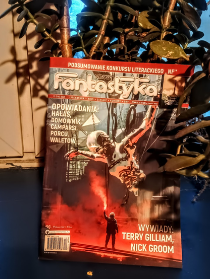 Zdjęcie czasopisma "nowa fantastyka" z widoczną okładką. Ilustracja przedstawia człowieka stojącego z zapaloną racą przed korpusem wielkiego człekoształtnego robota.
Na okladce napisy:
Opowiadania: Hałas, Domownik, Camparsi, Porcu, Waletow.
Wwywiady: Terry Gilliam, Nick Groom