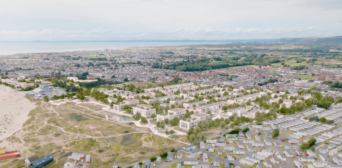 Coastal town with beach, caravan park, and residential housing.