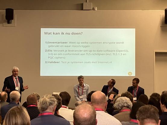 Foto van sprekers tijdens sessie met slide op achtergrond waarop de volgende tekst staat:
————
Wat kan ik nu doen?
1) Inventariseer: Weet op welke systemen encryptie wordt
gebruikt en waar risico's liggen
2) Eis: Verzoek je leverancier om up-to-date software (OpenSSL
3.0) en om conformiteit aan TLS-richtlijnen (incl. TLS 1.3 en
PQC ciphers)
3) Valideer: Test je systemen zoals met Internet.n|
————