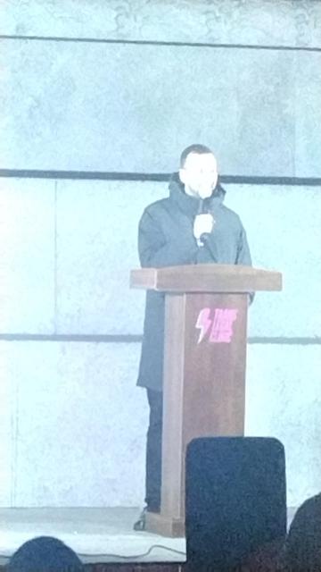 Zach Polanski on the podium set up by the Trans Legal Clinic