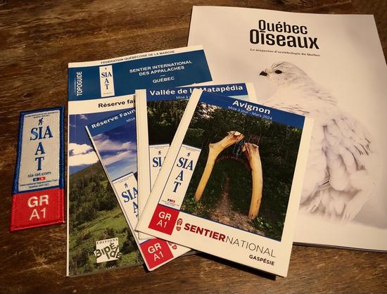 Trois cartes topographiques du Sentier international des Appalaches (SIA), un topo-guide de la Réserve de Matane, une badge du SIA et la dernière édition du magazine Québec Oiseaux.