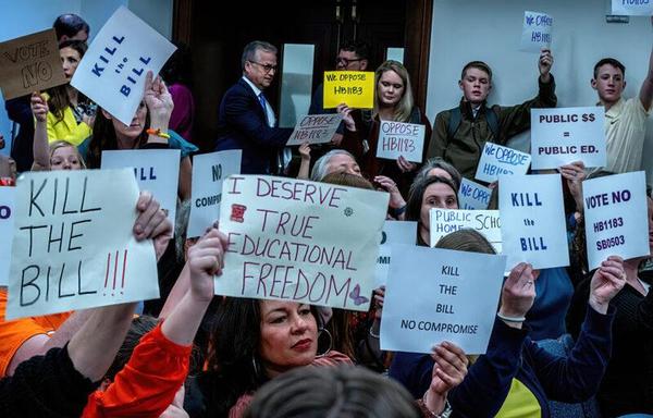 A group of people hold signs.