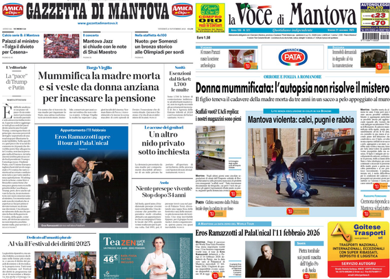Prima pagina di giornale proiettata su uno schermo in una stanza buia. Le testate principali visibili sono "Gazzetta di Mantova" e "La Voce di Mantova". I titoli maggiori riportano una notizia su una donna che mummifica la madre morta e si traveste da anziana per incassare la pensione, e su un caso di donna mummificata con l'autopsia che non risolve il mistero. Si vedono anche articoli di cronaca locale, uno spettacolo di Eros Ramazzotti e notizie sulla violenza e sugli asili. Ci sono alcune immagini a supporto degli articoli, tra cui una persona che canta e una donna vicino a un’auto.  .