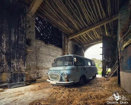 blue campervan left in a barn