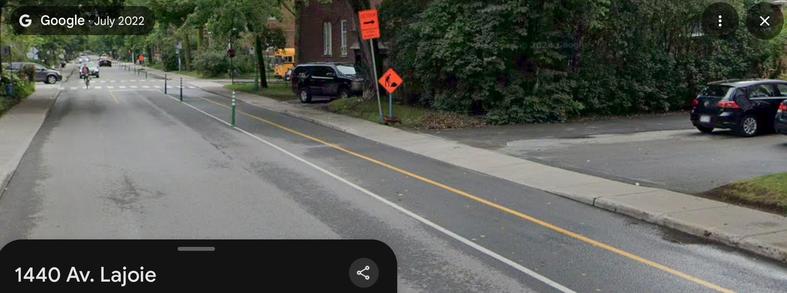 Photo de la piste cyclable de l'avenue Lajoie en 2022 (Google Street View), au 1440 Lajoie en direction est. On y voit la piste à double sens qui se réduit à une piste simple sens un peu avant l'école Lajoie.