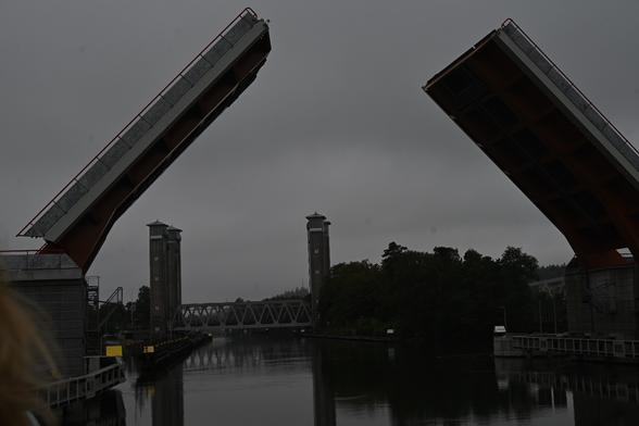 Kurz hintereinander queren zwei Brücken den Kanal, die vordere eine zweigeteilte Brücke mit Klapptechnik, die hintere eine Hubbrücke zwischen Pylonen.