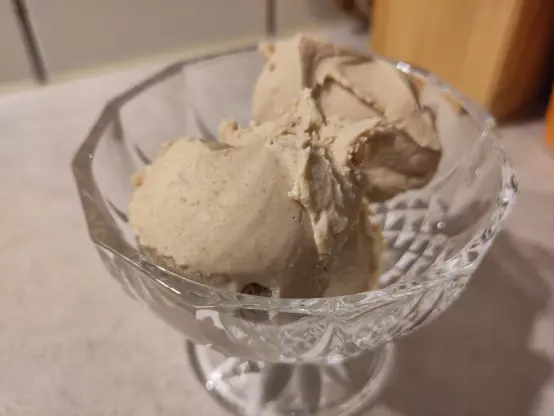 Drei unförmige Kugeln Walnuss Eiscreme in einer gläsernen Dessertschale
