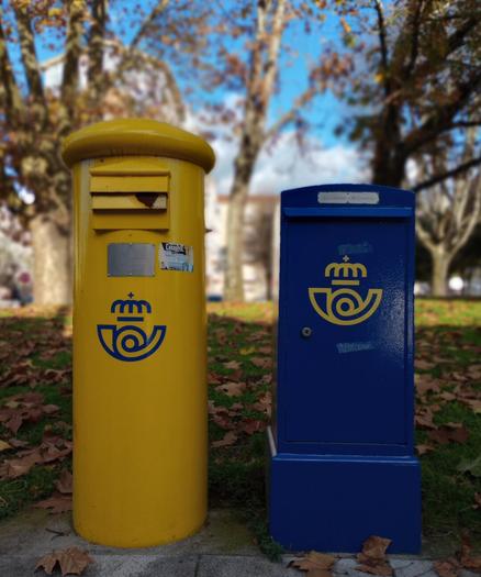 Yellow cylindrical mailbox and blue rectangular mailbox with postal service logos, outdoors with trees and fallen leaves.
#laureanoaraujo #santiagodecompostela #galiza
Santiago de Compostela, 21 de novembro de 2025