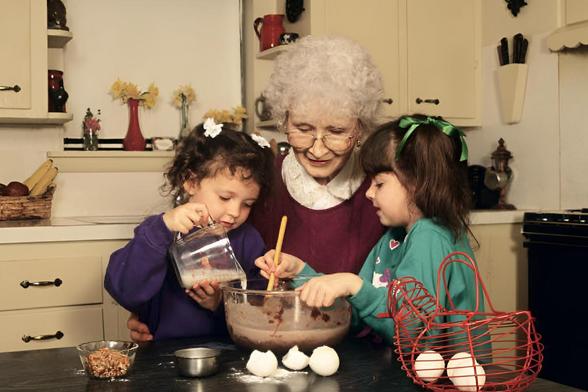 Una entrañable imagen de una abuela haciendo un bizcocho con sus dos nietas pequeñas. (Getty Images)