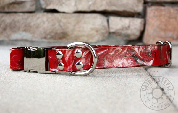 A red leather collar with a silver side-release buckle, adjustable slider, and D-ring. The strap is marbled with dark red and metallic silver.