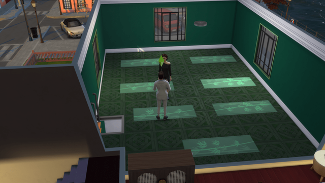 A yoga instructor is guiding a participant in a brightly colored room with yoga mats on the floor.