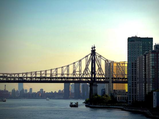 Late afternoon overlooking a river and a metal bridge in NYC.