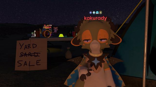 Screenshot of a virtual environment where a green dragon avatar with tan belly and orange highlights standing in front of a tent next to a table with knickknacks, including a red plastic cup, a stamp, a yellow letter "O" from a sign, and an icon of an executable file with the label "poyomi". In front of the table is a flattened cardboard box painted with the words "Yard sard / sale" with the word "sard" crossed out