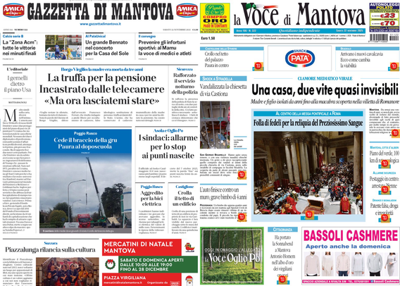 Due prime pagine di quotidiani locali di Mantova visualizzate su uno schermo in una stanza buia. A sinistra c’è la “Gazzetta di Mantova” e a destra “La Voce di Mantova”. I titoli principali della Gazzetta di Mantova sono “La truffa per la pensione incastrato dalle telecamere ‘Ma ora lasciatemi stare’”. La Voce di Mantova titola invece: “Una casa, due vite quasi invisibili”. Sono visibili anche alcune immagini: una di cronaca e una che mostra un’aula piena di persone. In basso ci sono spazi pubblicitari e notizie locali.