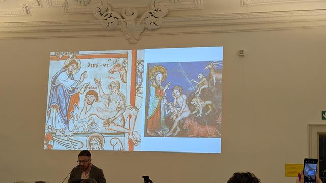 Colby Gordon in front of his presentation showing 2 Bible illustrations with Eve emerging from Adam's body's side