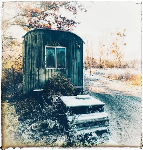 Ein winterlicher Bauwagen mit einer beschneiten Holztreppe davor