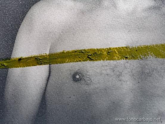 Se ve el pecho de un hombre y parte del brazo izquierdo. Fotografía en blanco y negro intervenida con un trazo de óleo color verde orgánico que atraviesa la foto de lado a lado por la mitad con una poca de inclinación hacia arriba a la derecha