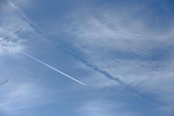 Blick auf eine dünne Wolkenschicht, darin ein Strich, wo die Wolken verschwunden sind.