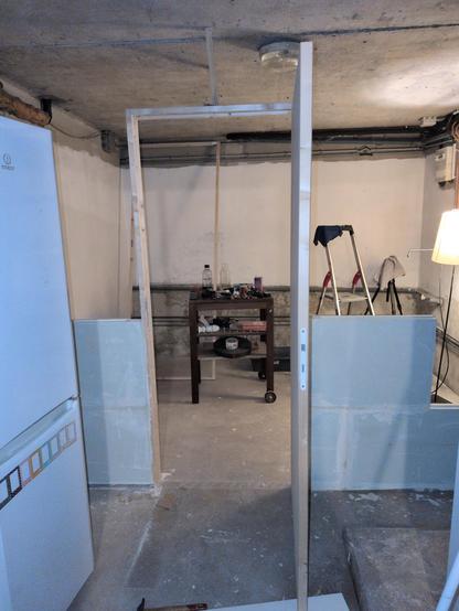 Photo d'une cloison en plaques de plâtre en cours de construction et dont la porte est ouverte