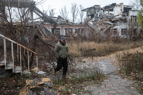 Dmytro Torets, Oekraïens oud-militair en een lokale journalist en activist, loopt op 19 november langs door Russische aanvallen verwoeste huizen in Slovjansk. Foto Kostyantyn Chernichkin

T