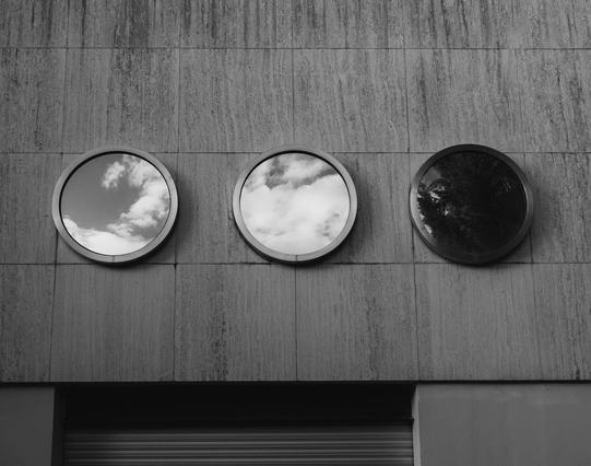 3 round windows on a concrete wall