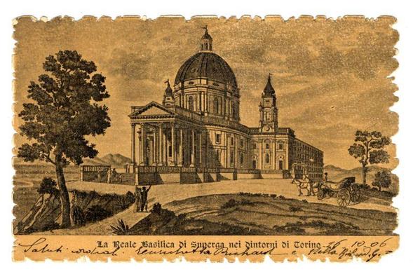 The image is a sepia-toned, antique-style print depicting La Reale Basilica di Superga in Turin. It features an architectural illustration of the basilica with its prominent dome and classical columns. The basilica appears grandiose, suggesting its historical significance.

In the foreground, there's a rural landscape that includes trees, a few scattered buildings, and what seems to be agricultural land or pasture. There are also two figures near the base of one of the buildings on the left side of the image, which might represent workers or travelers passing by.

On the right, outside the basilica grounds, there is an illustration of a carriage being pulled by horses, suggesting transportation methods from that era. The overall scene suggests this print was created to document and celebrate the architectural heritage of Turin during 1806-23 under Napoleon's regime when it served as his capital.

The text on the image reads "La Reale Basilica Di Superga nei dintorni di Torino" which translates from Italian, indicating that this basilica is located in the outskirts of Turin. Additional inscriptions and signatures are present but not legible here; however, they provide a personal touch to the print.

It's worth noting that such prints were commonly used as travel souvenirs or for educational purposes during the time period it was created.