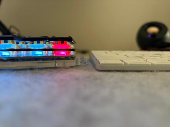 A image of two keyboards side by side from the desktop showing the difference in thickness of a Sofle v2 Hybrid with MX medium profile switches (left) and an Apple Magic keyboard (right).