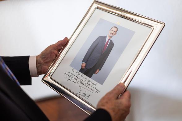 Alberto Aza, exjefe de la Casa del Rey, sostiene un retrato de Felipe VI.