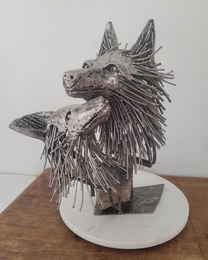 Une sculpture en acier représentant 2 têtes de renard : une maman qui regarde droit devant et un petit qui regarde maman. Leur pelage est composé de clous. Les têtes sont complètement modelées dans l'acier. 

Le tout est monté sur une jolie roche de granit rose provenant de Charlevoix.