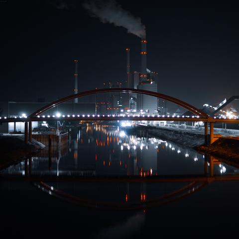Das Großkraftwerk Mannheim bei Nacht, im Vordergrund die Duisburger Brücke.