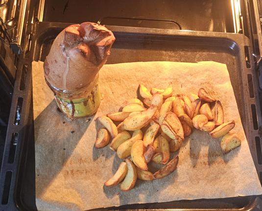 Backblech mit Kartoffelspalten und ein Glas Leberkäs