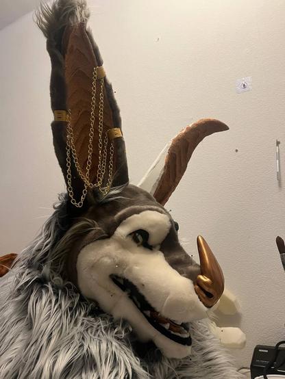 A photo of a w.i.p.bat  fursuit head with the freshly sewn fur draped on top, loosely.