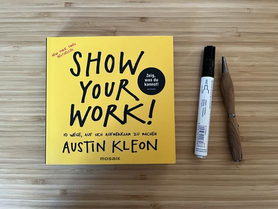 Außenansicht des Buches "Show Your Work" von Austin Kleon. Ein gelbes Cover mit schwarzem Schriftzug. Der Untertitel lautet: "10 Wege, auf sich aufmerksam zu machen".