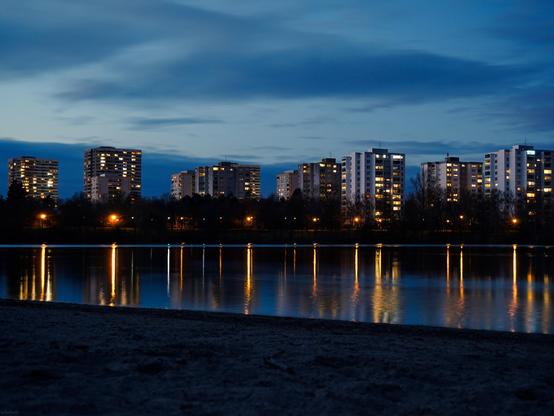 Die Skyline von Mannheims Stadtteil Vogelstang im See gespiegelt.