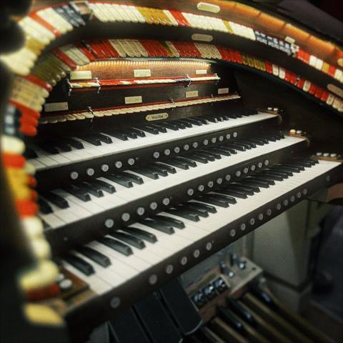 A Mighty Wurlitzer pipe organ's keys fill the frame, with additional tabs and foot pedals lining it above and below.