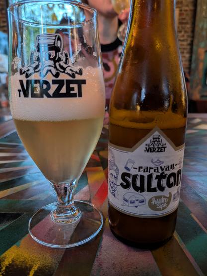 A glass of lightly coloured beer called Caravan Sultan and its bottle.